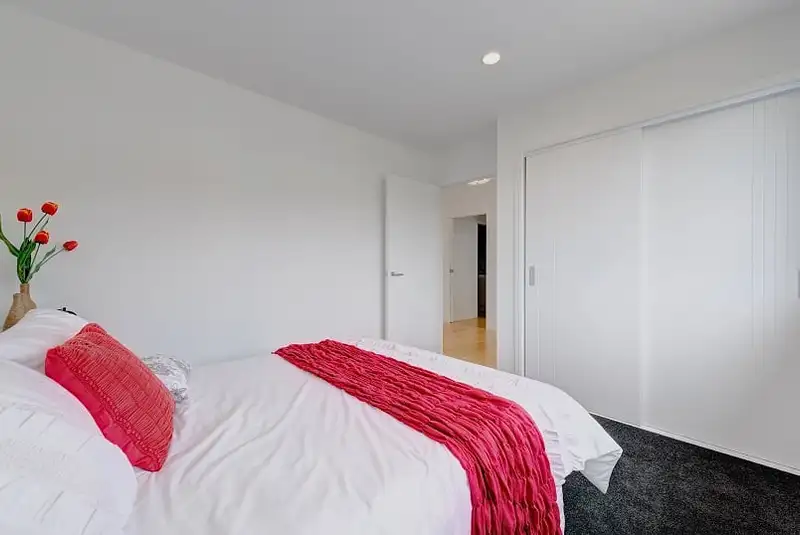 A bedroom with a wall of sliding wardrobe doors.