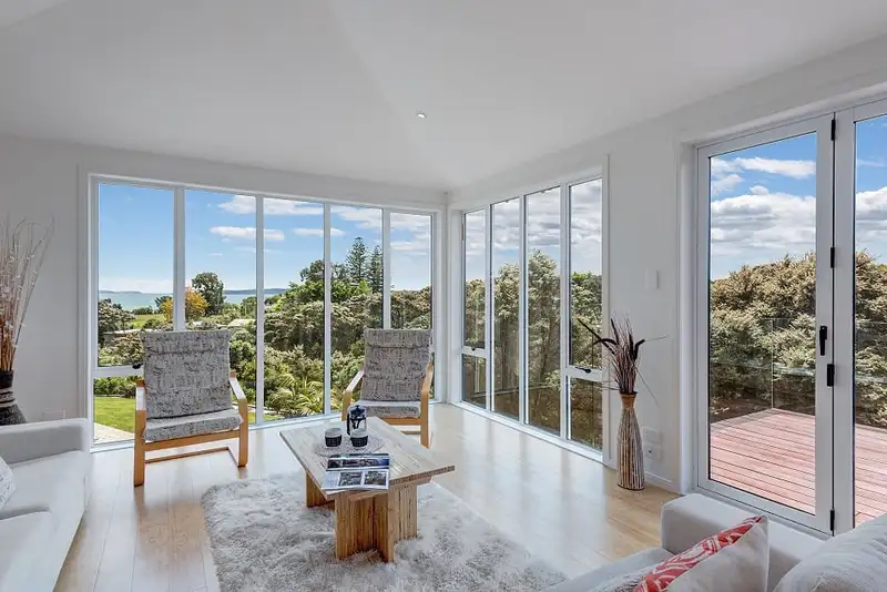 The lounge, with windows on two sides looking over the bush to the sea.