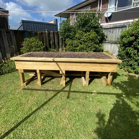 The raised bed filled with soil and in position in the garden.